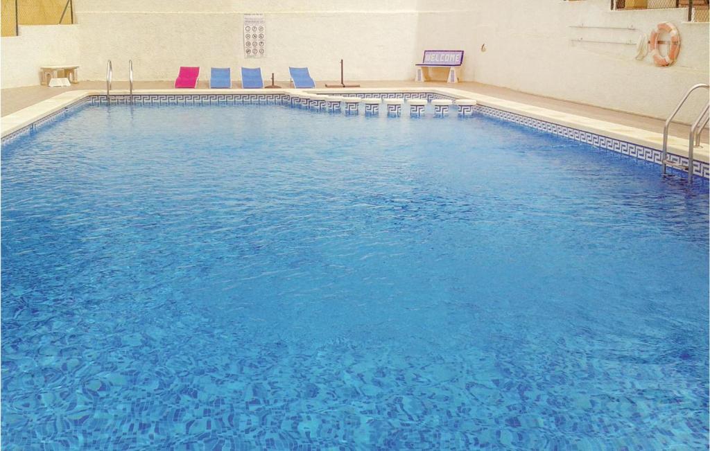 een groot zwembad met blauw water in een gebouw bij 1 Bedroom Gorgeous Apartment In Rojales in Rojales