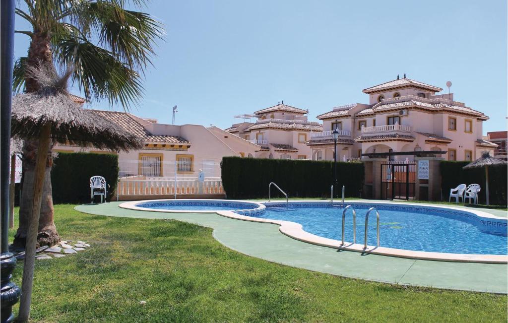a large swimming pool in front of a house at 2 Bedroom Lovely Home In Orihuela Costa in Orihuela Costa