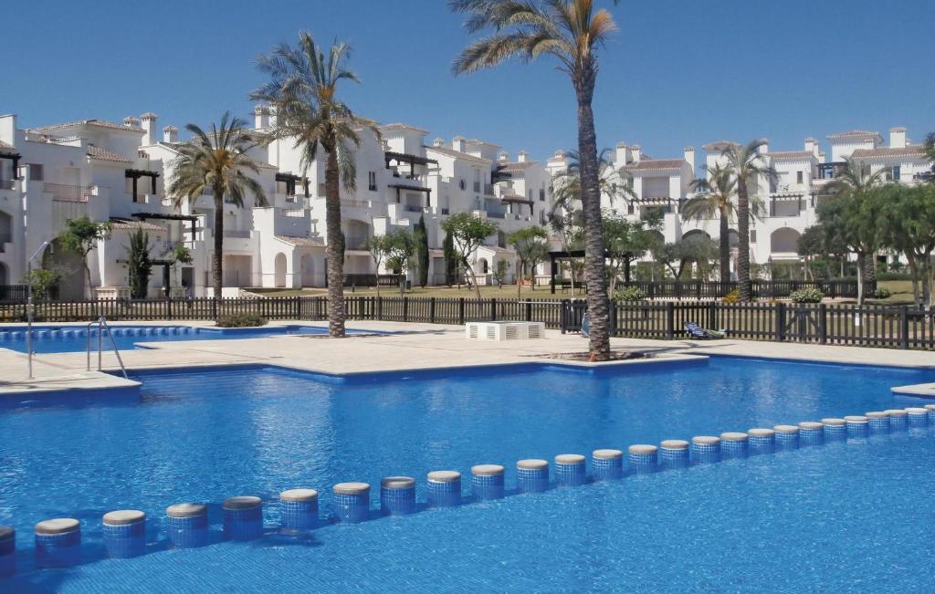 een groot zwembad met palmbomen en gebouwen bij Nice Apartment In Roldn With 2 Bedrooms, Internet And Outdoor Swimming Pool in Los Tomases