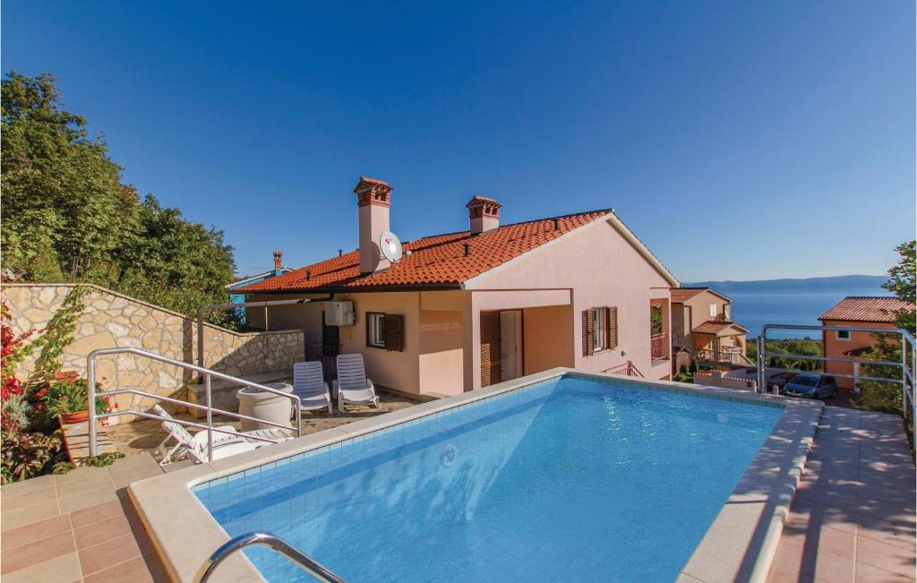 a villa with a swimming pool in front of a house at Cozy Home In Labin With Wifi in Drenje