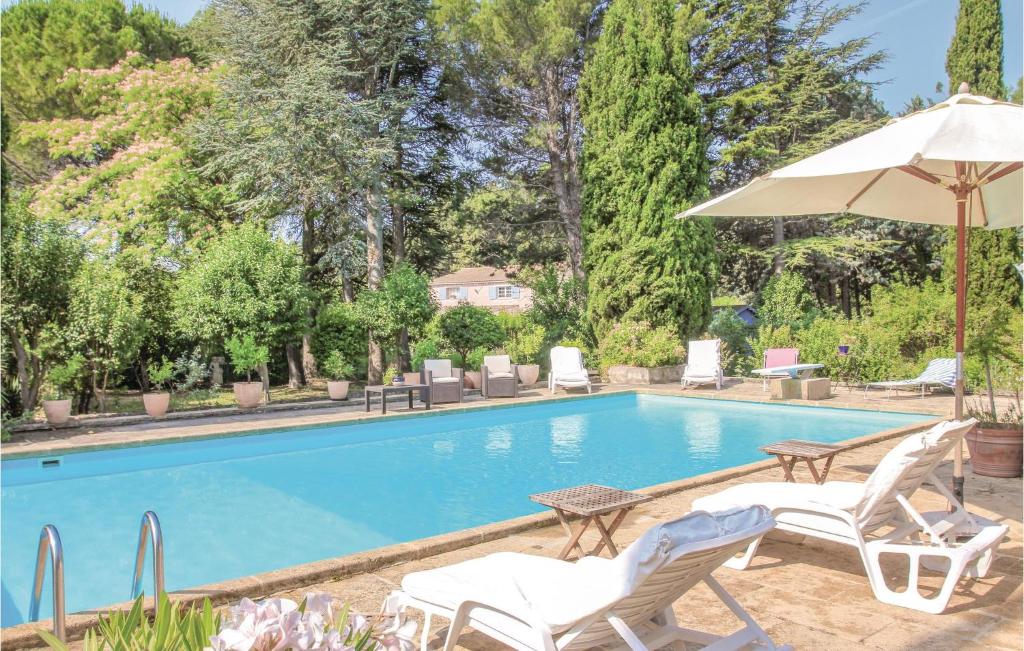 a swimming pool with two chairs and an umbrella at Amazing Home In Lançon De Provence in Lançon-Provence