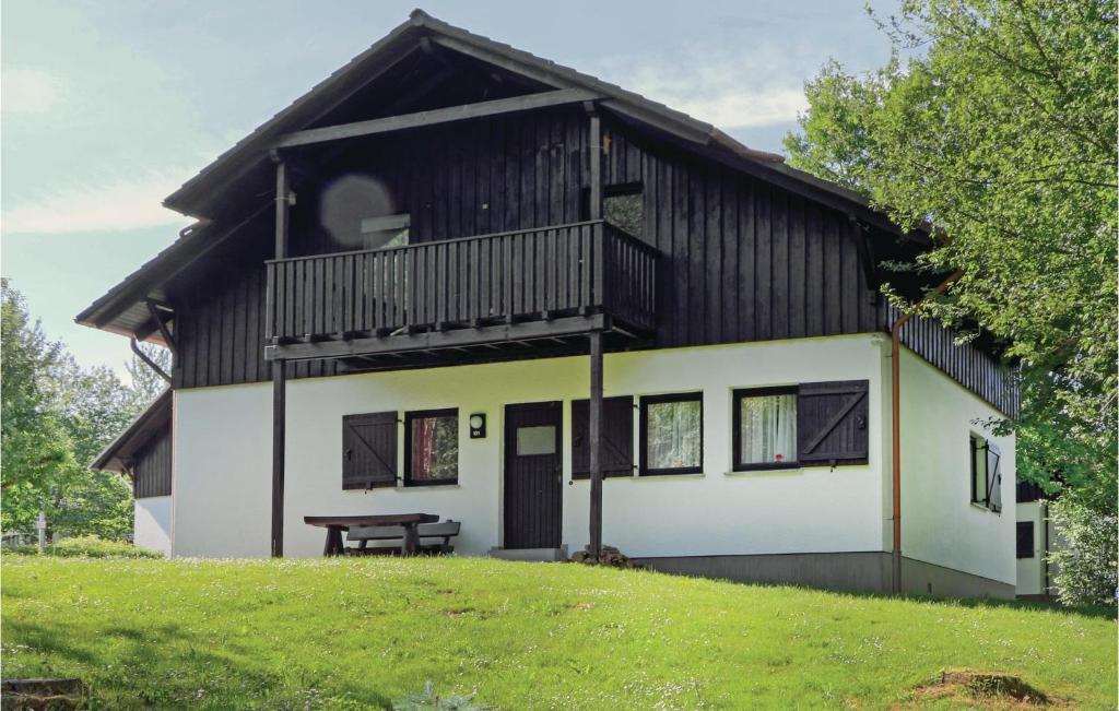 a house with a balcony and a picnic table in front of it at Ferienhaus 6 In Thalfang in Thalfang