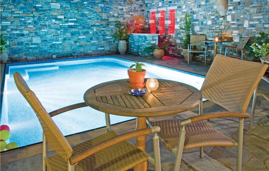 ポルタリアにあるAmazing Home In Portaria With Jacuzzi, Wifi And Outdoor Swimming Poolのスイミングプールの横のテーブルと椅子
