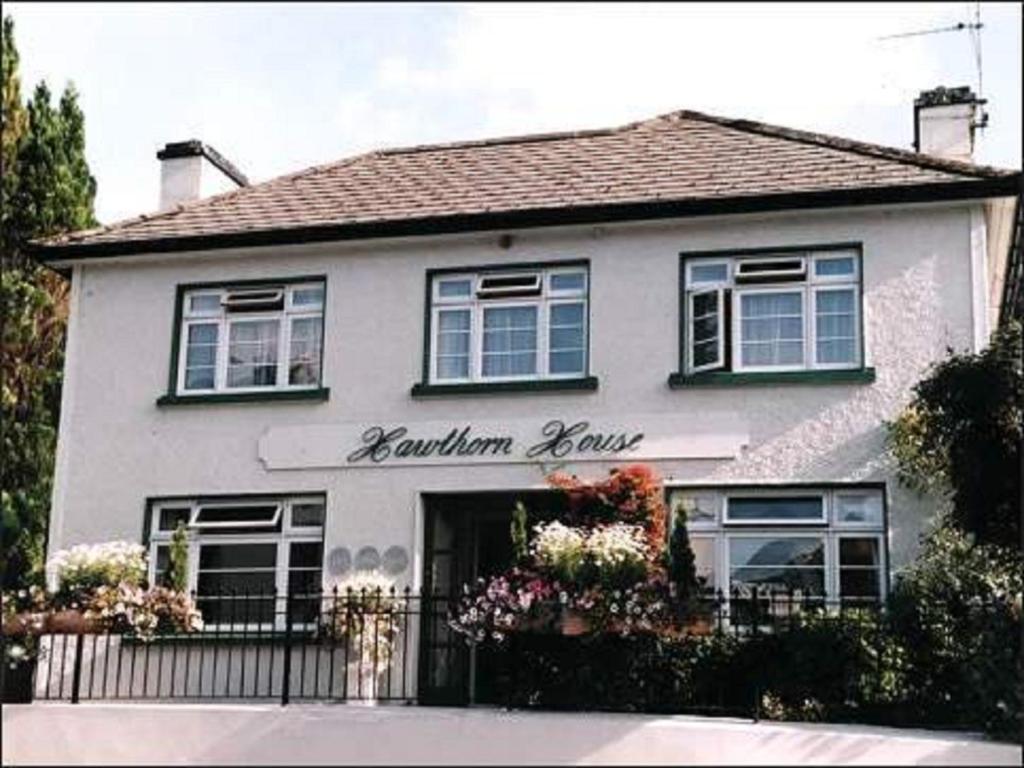una casa blanca con un signo de boutiqueounge en Hawthorn House Guesthouse, en Kenmare