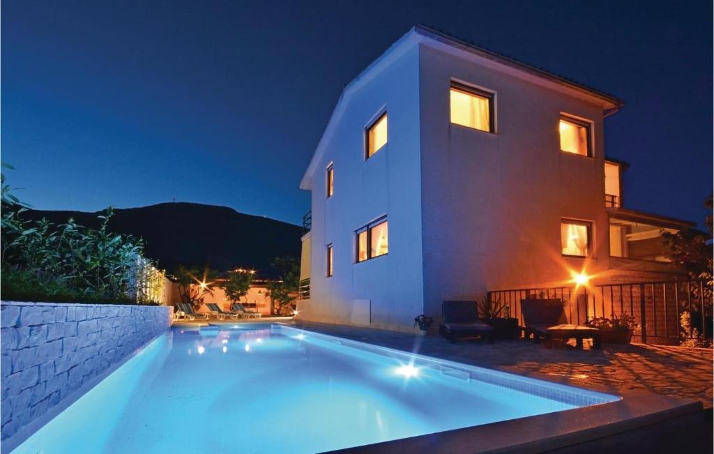 a swimming pool in front of a house at night at Nice Home In Kastel Novi With Outdoor Swimming Pool in Kaštela