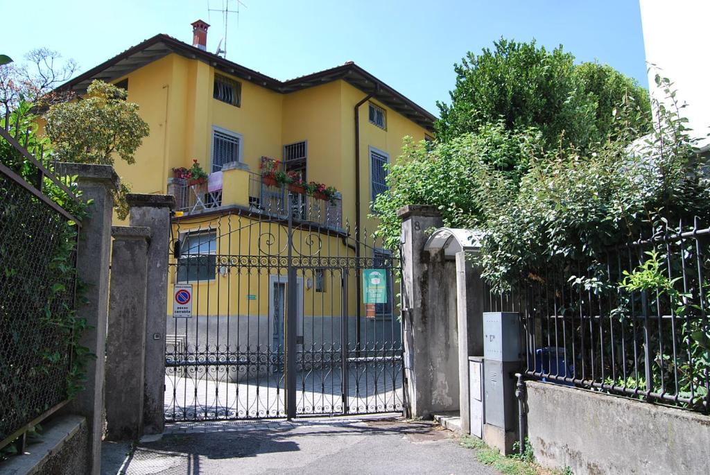 żółty dom z bramą i płotem w obiekcie Bergamo Bassa w Bergamo