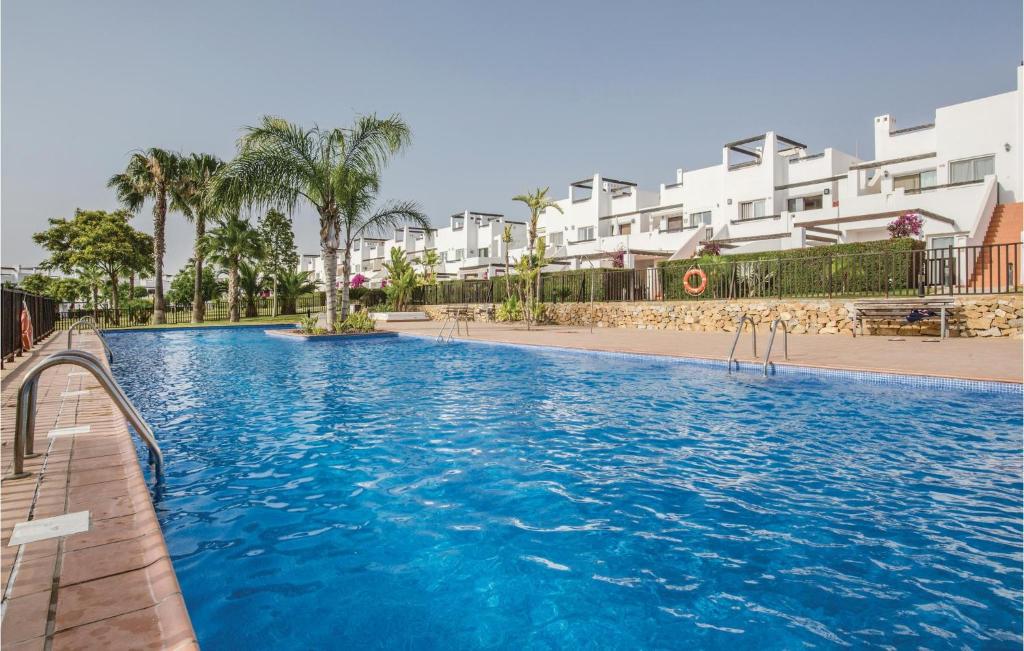La MolataにあるStunning Apartment In Alhama De Murcia With 2 Bedrooms, Internet And Outdoor Swimming Poolの一部の建物の前に大きなスイミングプールがあります。