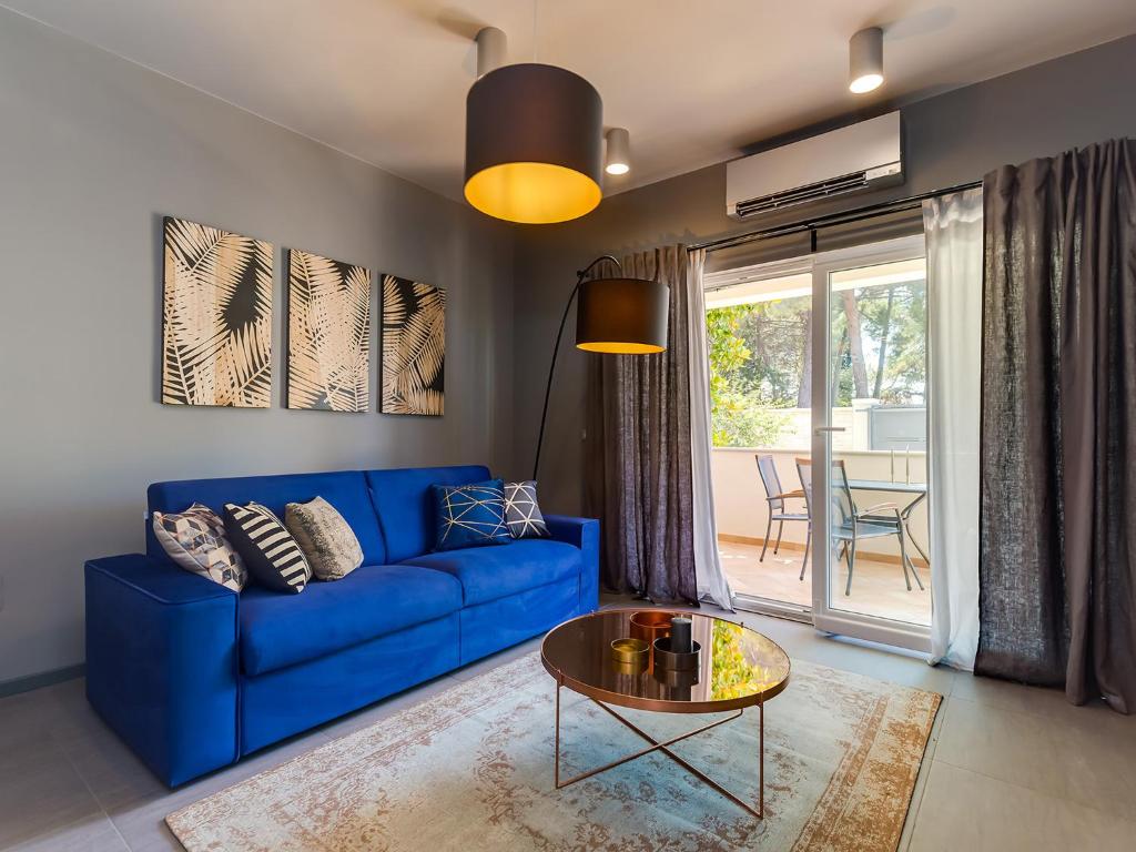 a blue couch in a living room with a table at Magnolia - Modern Apartment near City Center and Sea in Poreč
