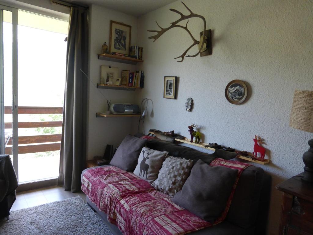 a living room with a couch and a window at Grande Chaume A123 in Le Sauze