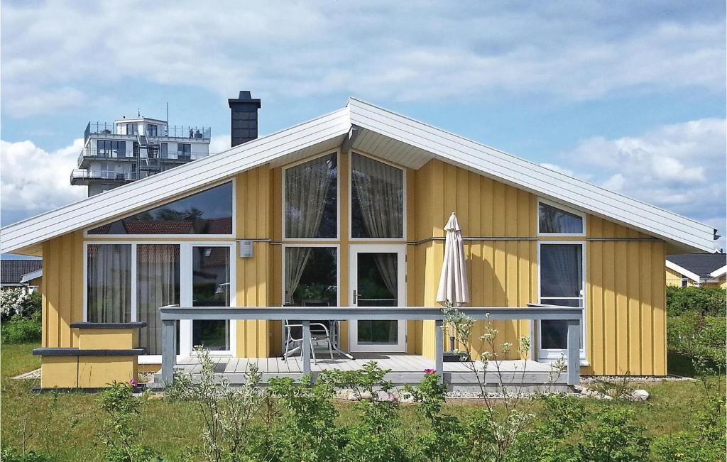 żółty dom z dużym oknem i parasolem w obiekcie Nice Home In Rechlin With Sauna w mieście Rechlin
