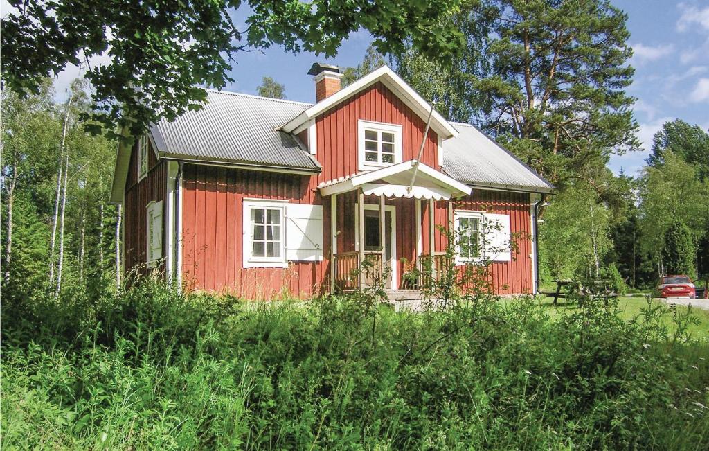 une maison rouge assise au milieu d'un champ dans l'établissement Gorgeous Home In Vislanda With Kitchen, à Vislanda