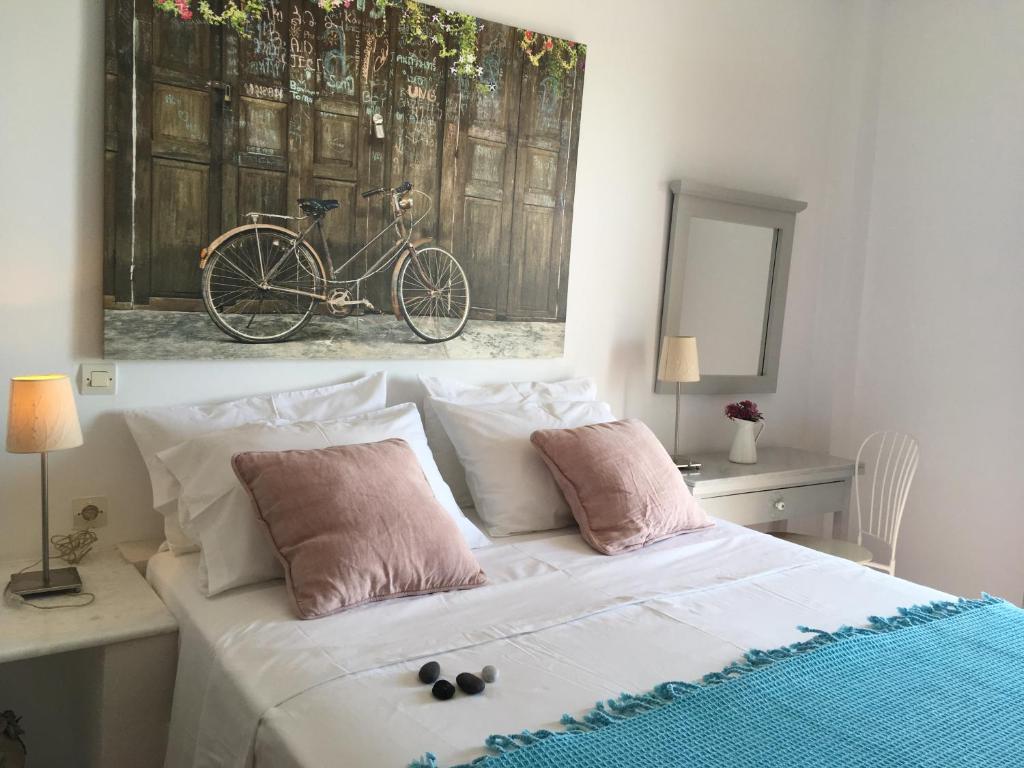 a bedroom with a bed with a bike painting on the wall at Alonia Studios in Firostefani