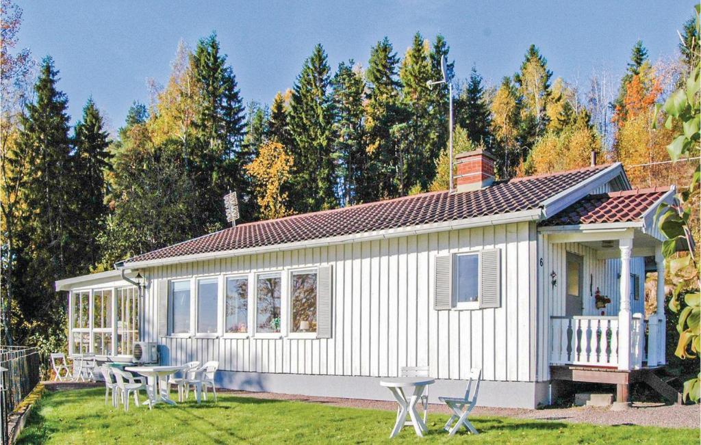Nice Home In Kil With House Sea View في Säbytorp: كوخ أبيض صغير مع طاولة وكراسي