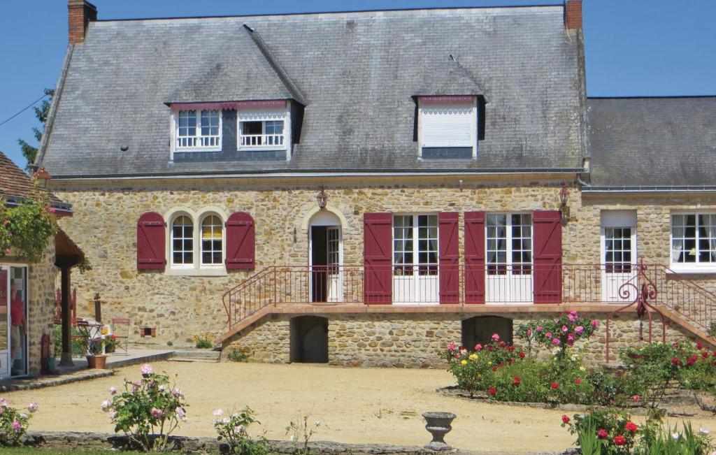 ein altes Steinhaus mit roten Rollläden in der Unterkunft Gorgeous Home In Juigne Sur Sarthe With Wifi in Sablé-sur-Sarthe