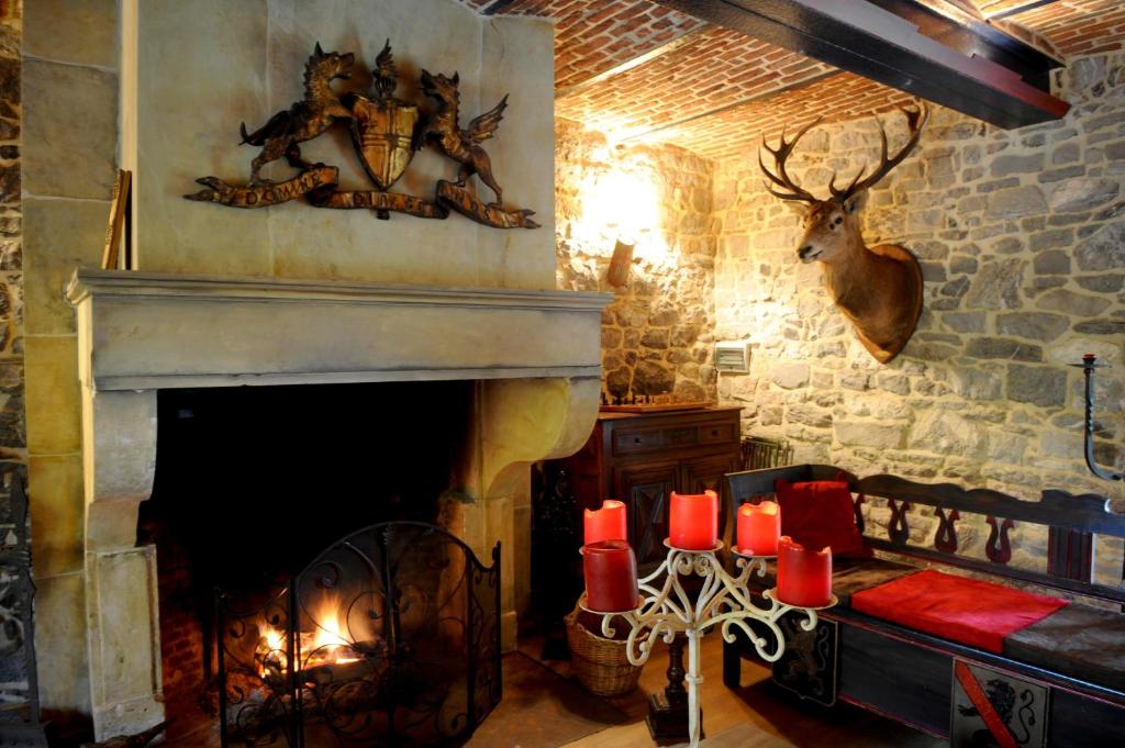 a living room with a fireplace with red candles at Les Confidences de Messire Sanglier, stylished guest houses in Beauraing
