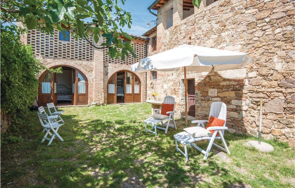 a group of chairs and an umbrella in a yard at Schivanoia 2 in Bagno Vignoni