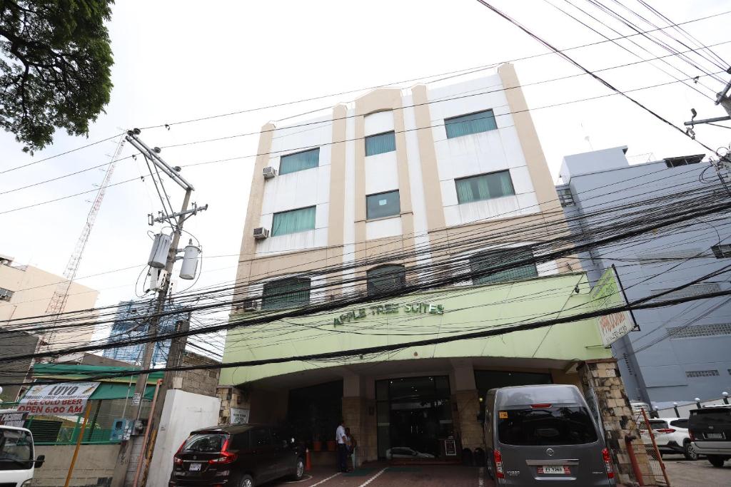 a building with cars parked in front of it at OYO 210 Apple Tree Suites in Cebu City