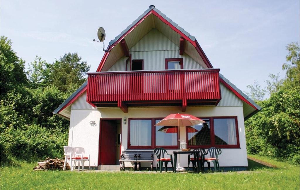 ein Haus mit einem Tisch und Stühlen und einem Sonnenschirm in der Unterkunft Ferienhaus 120 In Kirchheim in Kirchheim