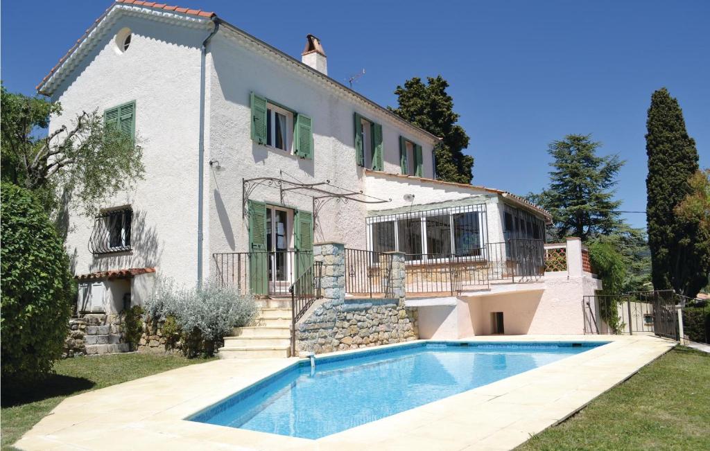 a villa with a swimming pool in front of a house at Gorgeous Home In Cabris With Wifi in Cabris