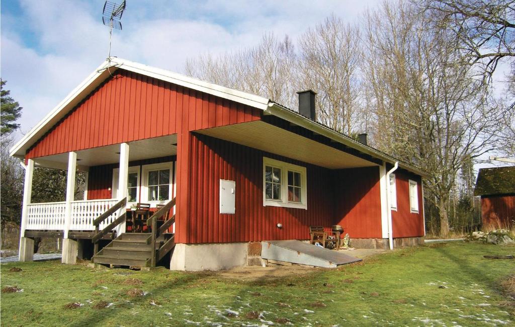 una casa roja con porche y escaleras a ella en Holiday Home Agunnaryd with Fireplace VII, en Agunnaryd