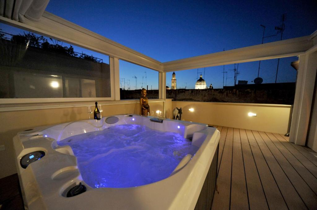 a jacuzzi tub in a room with a balcony at B&B Palazzo San Michele in Bari