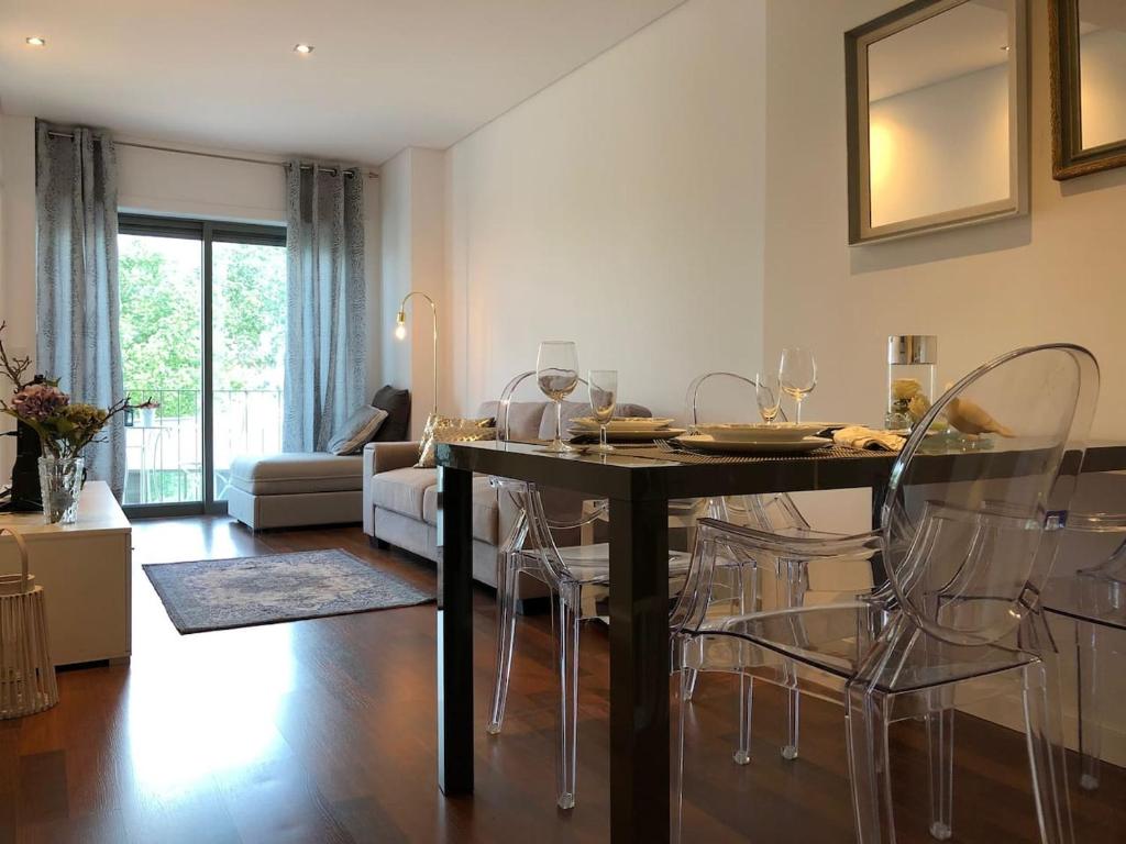 sala de estar con mesa de comedor y sillas en Deluxe Apartment - Aveiro Train Station, Center, en Aveiro