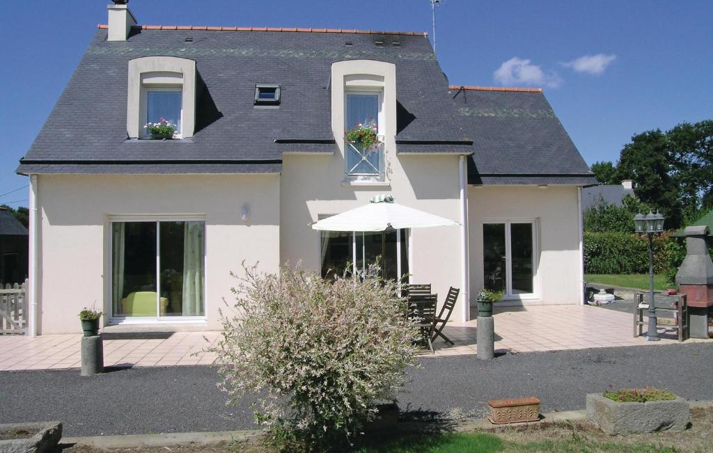 a white house with a table and an umbrella at Awesome Apartment In Roz-landrieux With Kitchen in Roz-Landrieux