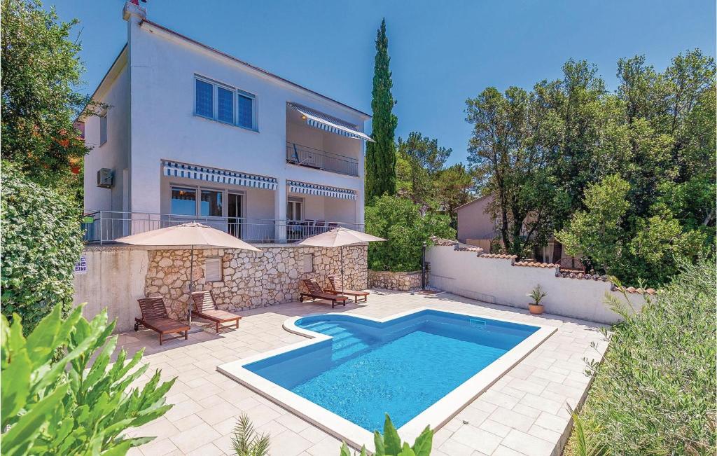 a villa with a swimming pool in front of a house at Amazing Home In Crikvenica With 4 Bedrooms, Wifi And Outdoor Swimming Pool in Dramalj