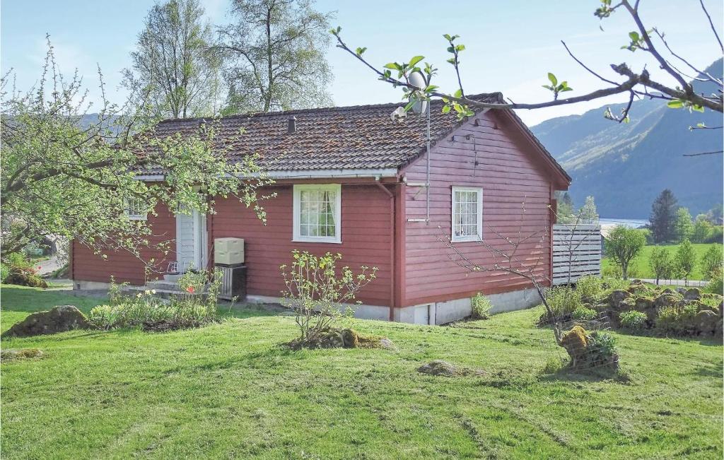 a red house in a field with a yard at Beautiful Home In Hovsherad With Kitchen in Handeland