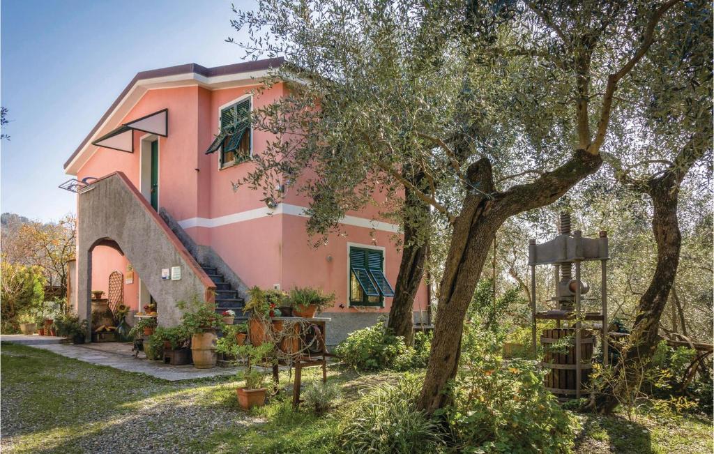 une maison rose avec un arbre devant elle dans l'établissement Pian Dellaia 2, à Bracco