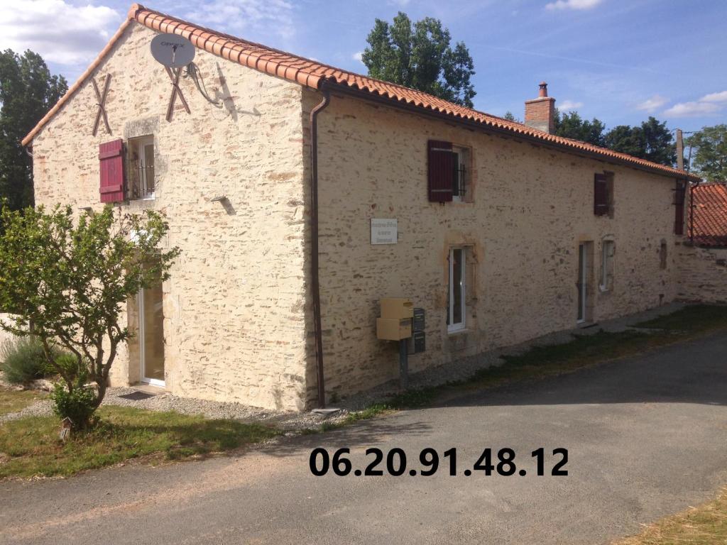 una gran casa de piedra en una calle en Chambres d'hôtes "La Source", en Mareuil-sur-Lay