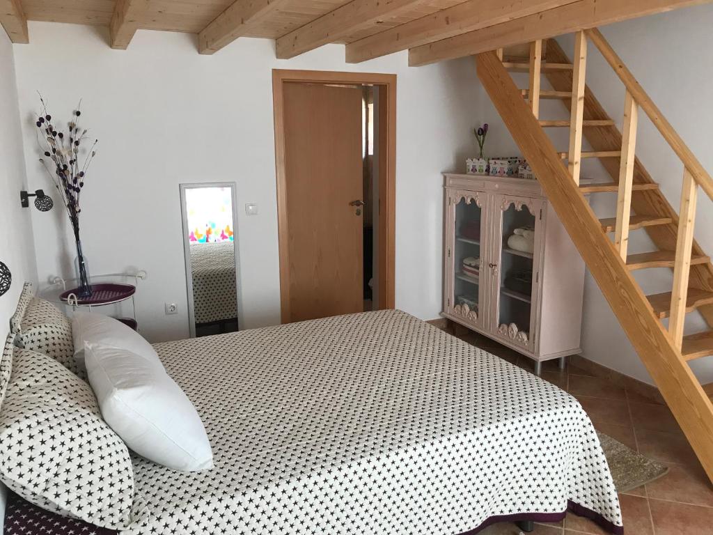 a bedroom with a bed and a wooden staircase at Vila Velha Guest House in Mértola