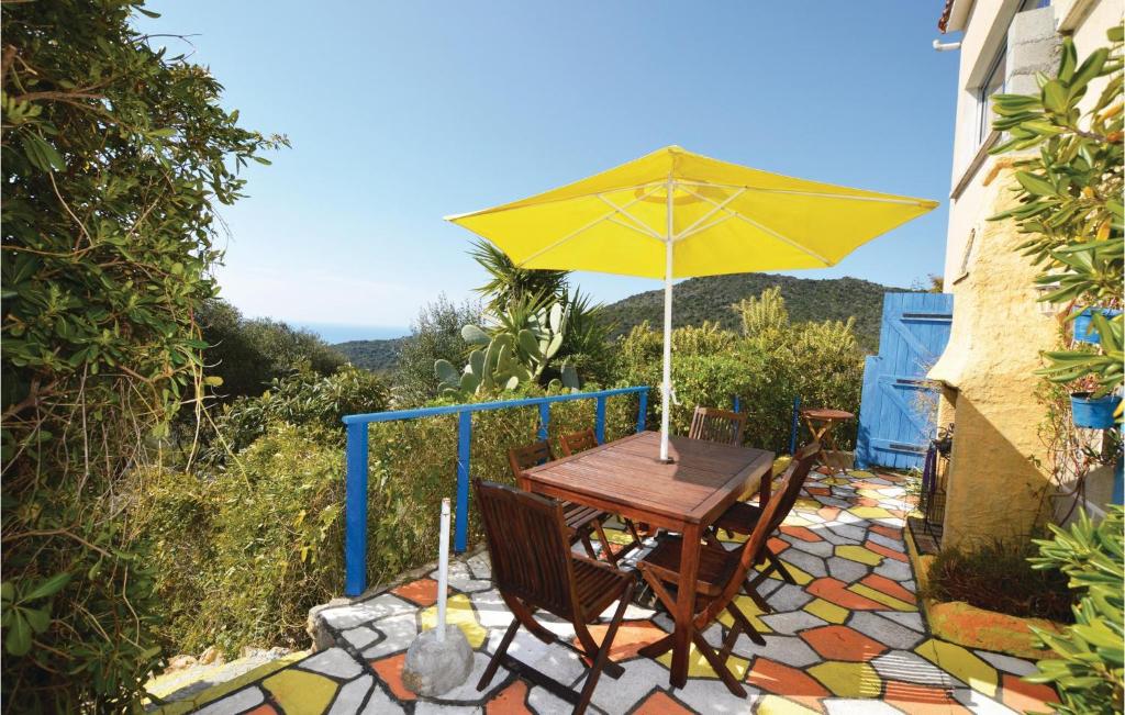 セラ・ディ・フェロにあるCozy Apartment In Serra Di Ferro With House Sea Viewの木製テーブル(パティオの黄色い傘付)