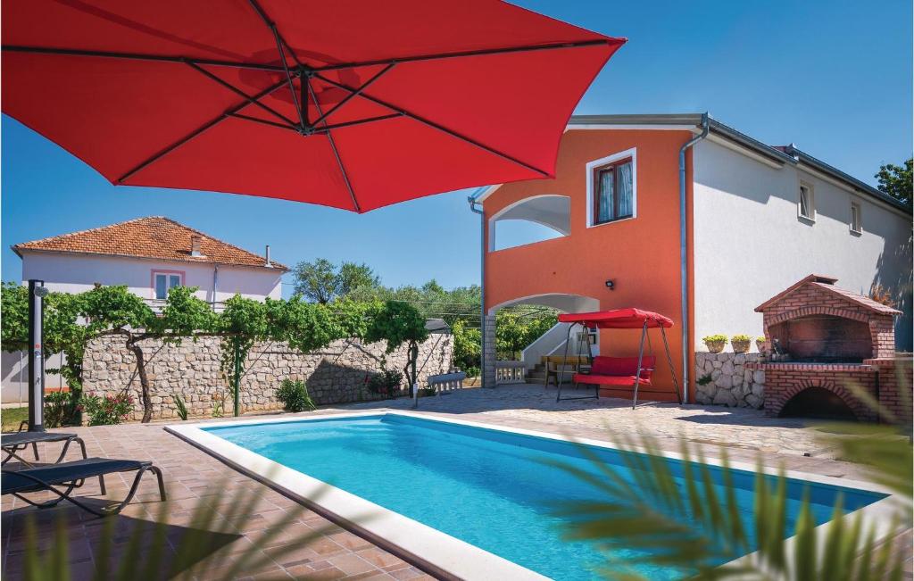 Casa con piscina y sombrilla roja en Lovely Home In Kraj With Wifi, en Kraj