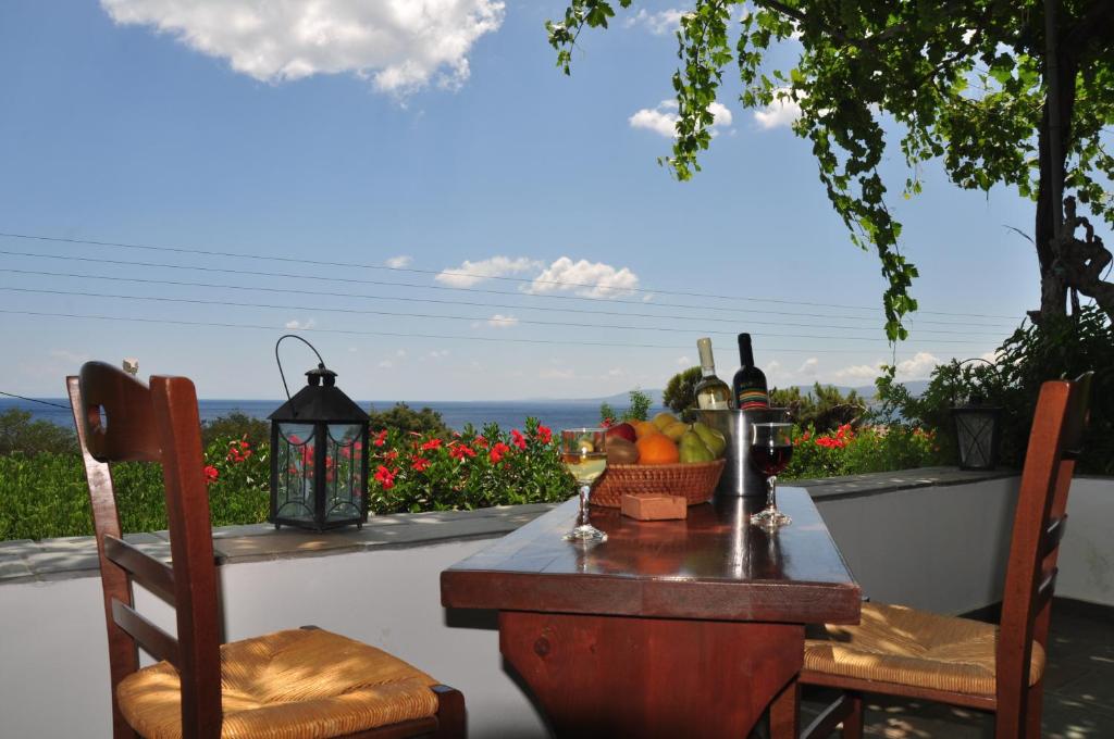 a table with bottles of wine and a basket of fruit at Villa Panorama in Pefkos in Pefki