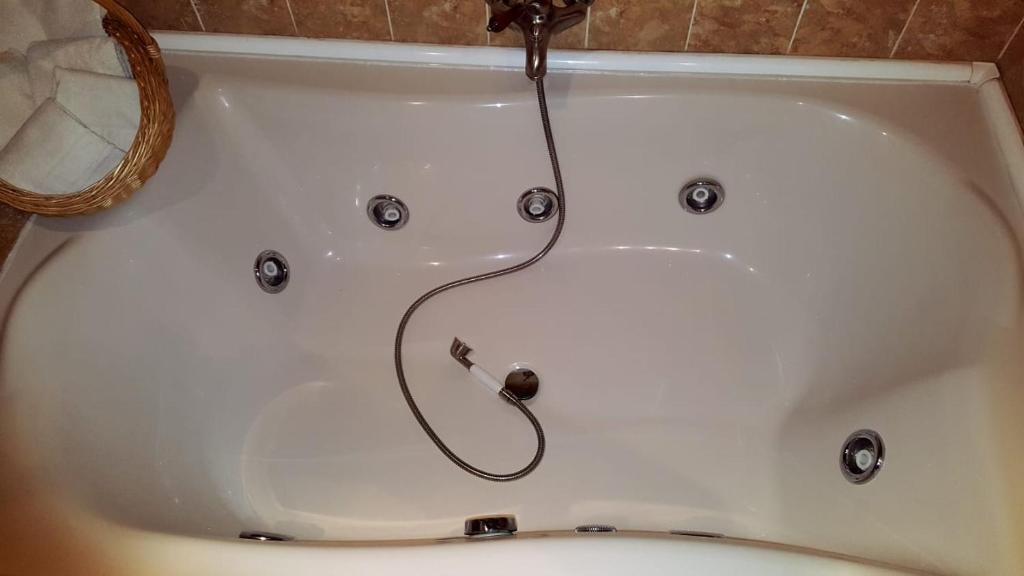 a bath tub with a faucet and a hose at Madre Terra in La Puebla de la Sierra