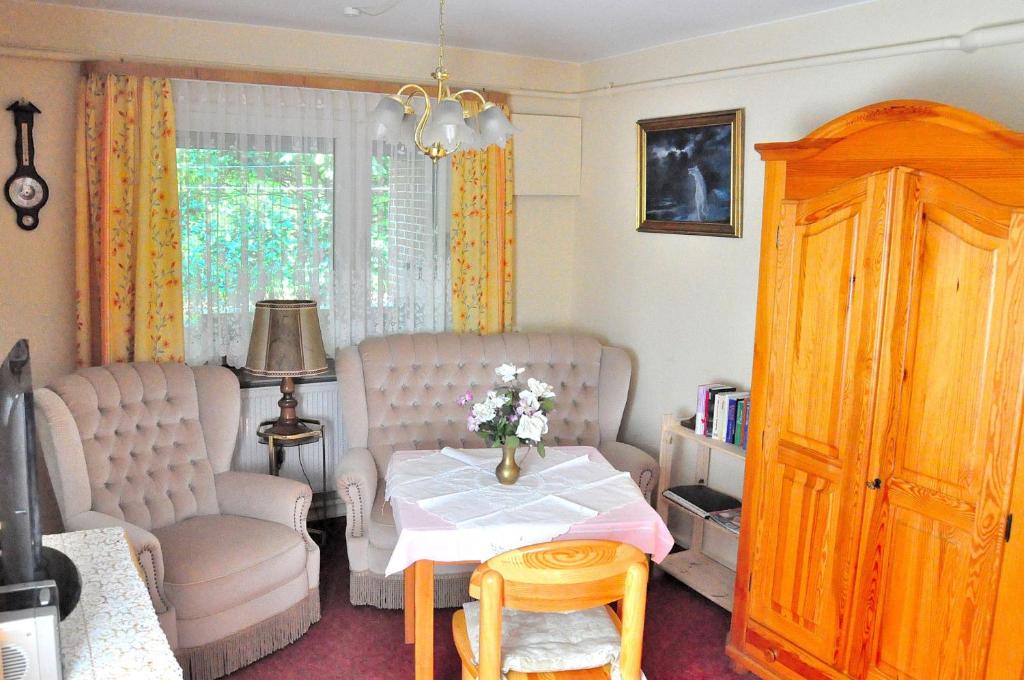 a living room with a table and chairs and a window at Appartement Am Schulwald in Büsum