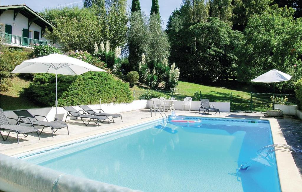 ユスタリッツにあるGorgeous Home In Ustaritz With Private Swimming Pool, Can Be Inside Or Outsideの大きなスイミングプール(椅子、パラソル付)