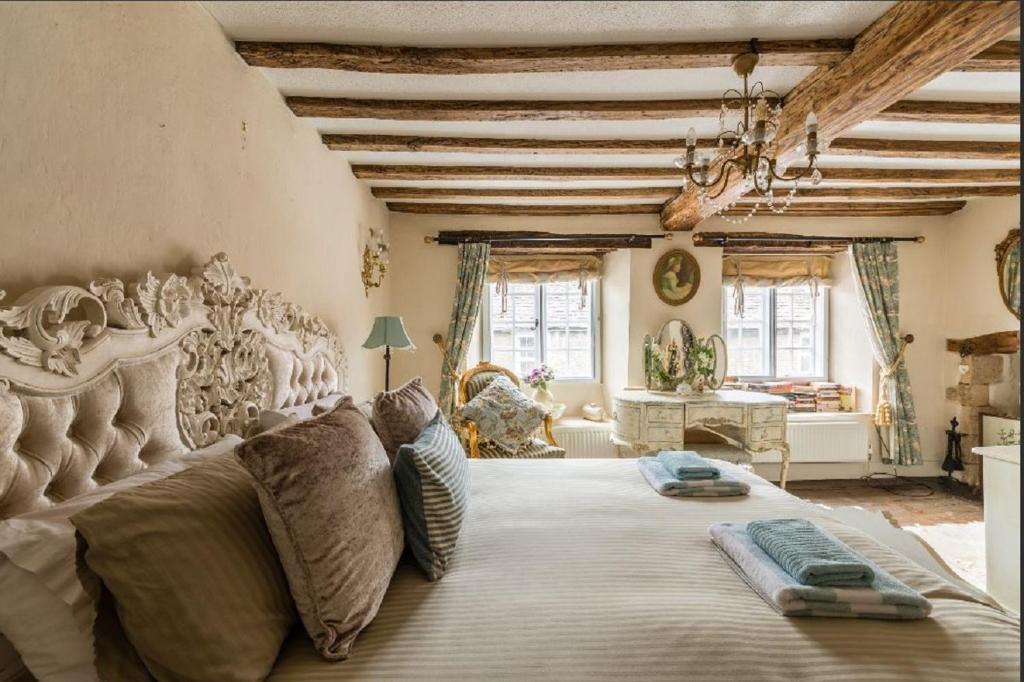 ein großes Schlafzimmer mit einem großen Bett in einem Zimmer in der Unterkunft Tudor Cottage in Fairford