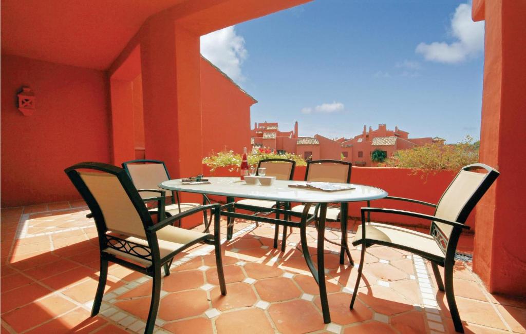 un patio con tavolo e sedie sul balcone. di Beautiful Apartment In Marbella-el Rosario With Kitchen a Mijas Costa