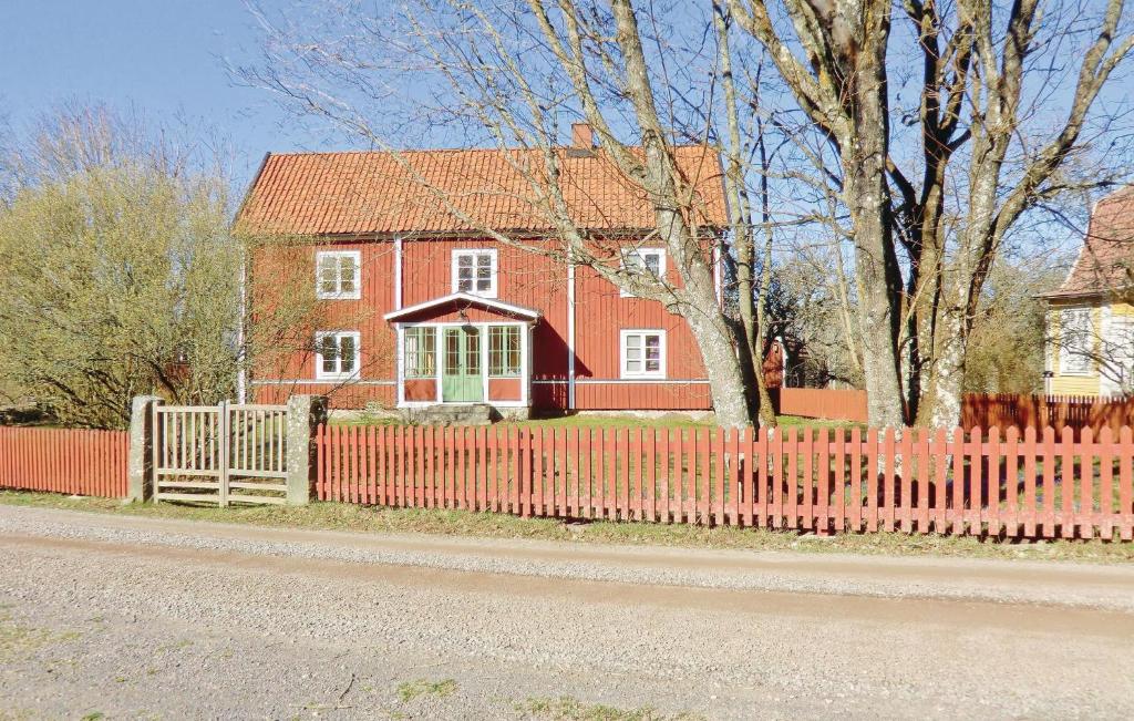 une maison rouge avec une clôture devant elle dans l'établissement Gorgeous Home In rsj With Wifi, à Kopparfly