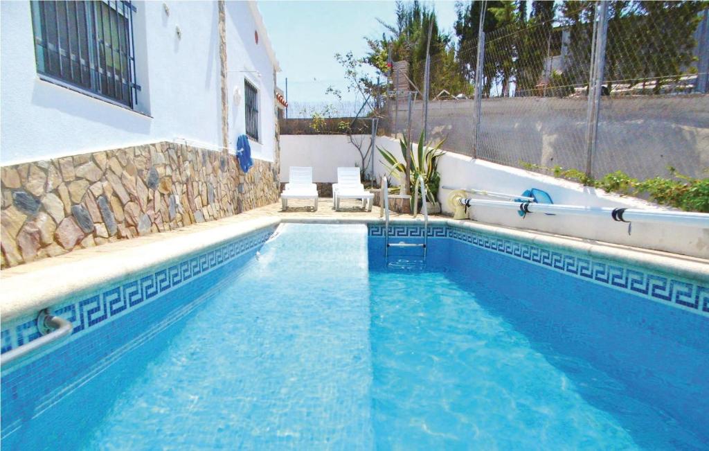 ヴィドレレスにあるStunning Home In Vidreres With 3 Bedrooms, Outdoor Swimming Pool And Wifiの青いスイミングプール(椅子2脚付)