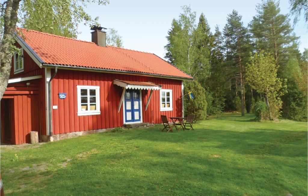 uma casa vermelha com uma mesa de piquenique em frente em 3 Bedroom Amazing Home In lgars em Älgarås