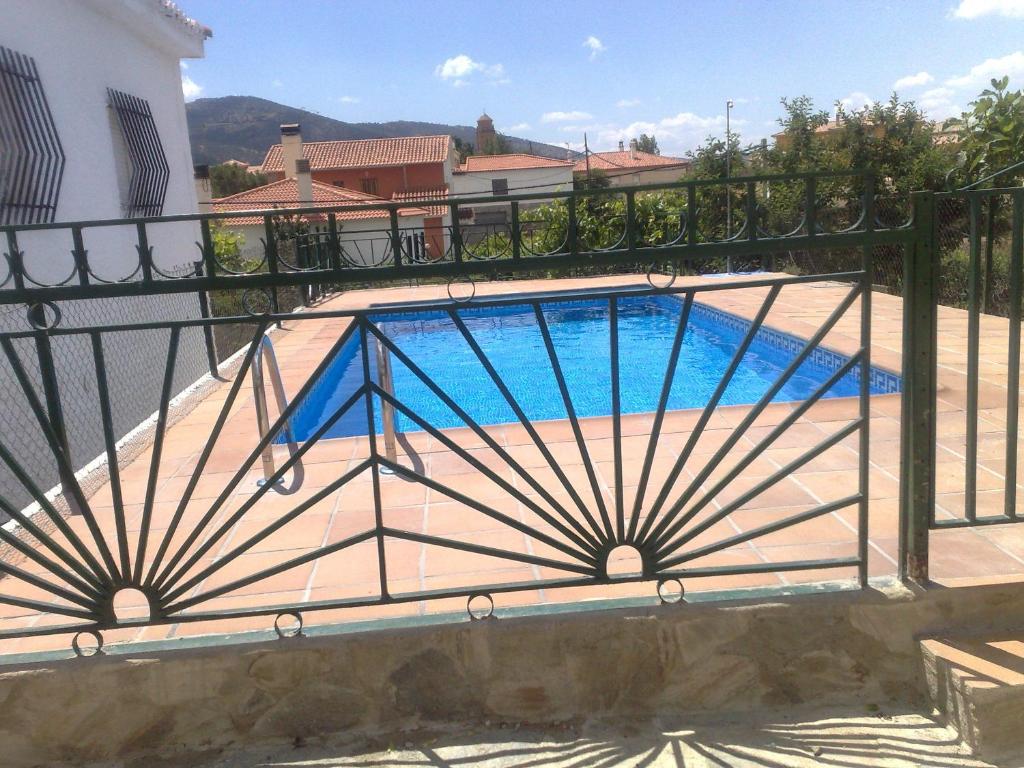 a swimming pool with a metal fence around it at Casa Detrés in Cogollos de Guadix