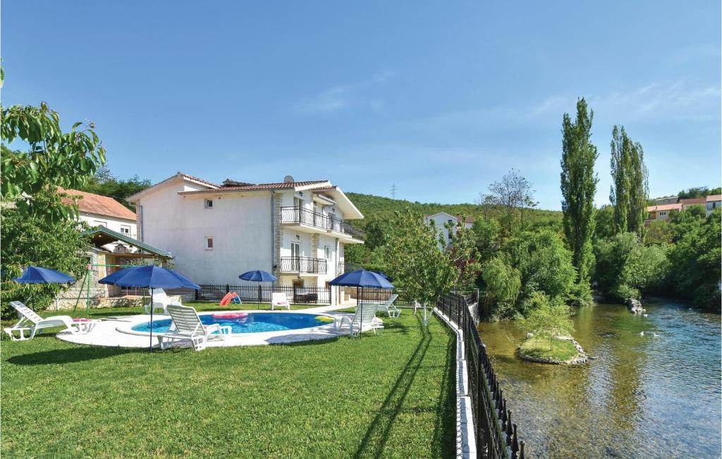 une maison avec une piscine à côté d'une rivière dans l'établissement Nice Home In Grab With Wifi, à Grab