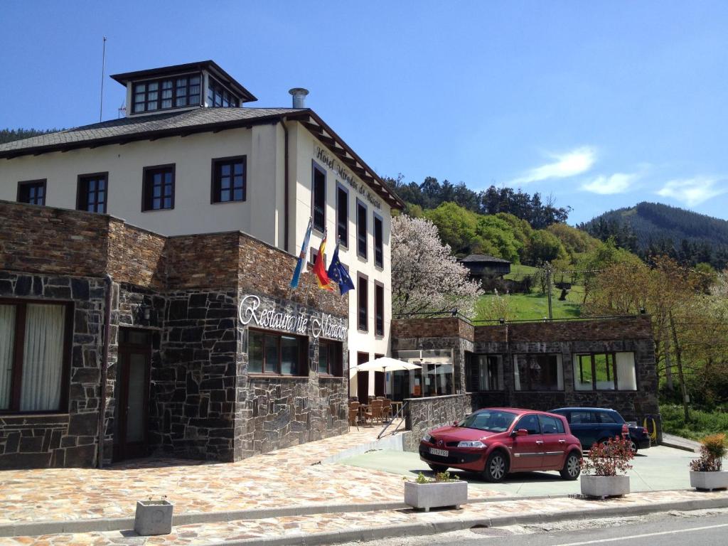 un'auto rossa parcheggiata di fronte a un edificio di Hotel Mirador de Barcia a Ribeira de Piquin