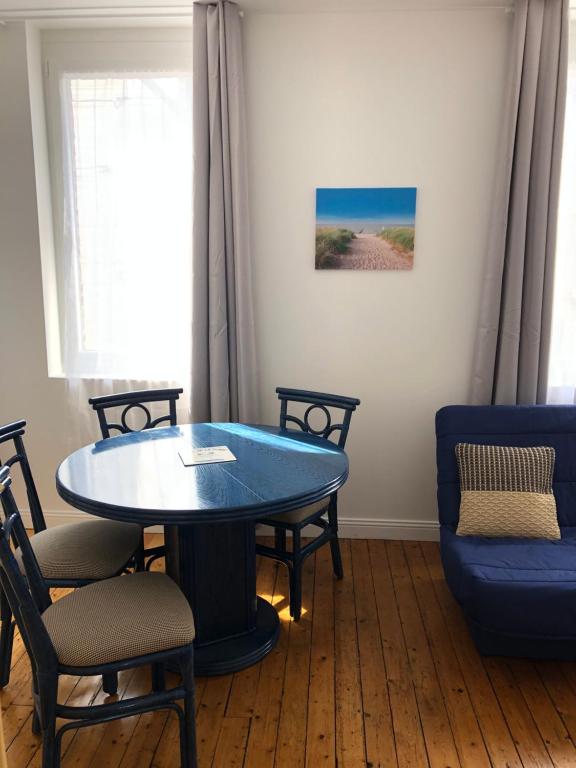 une salle à manger avec une table et des chaises bleues dans l'établissement Appartement à 2 minutes de la plage 5 places, à Berck-sur-Mer