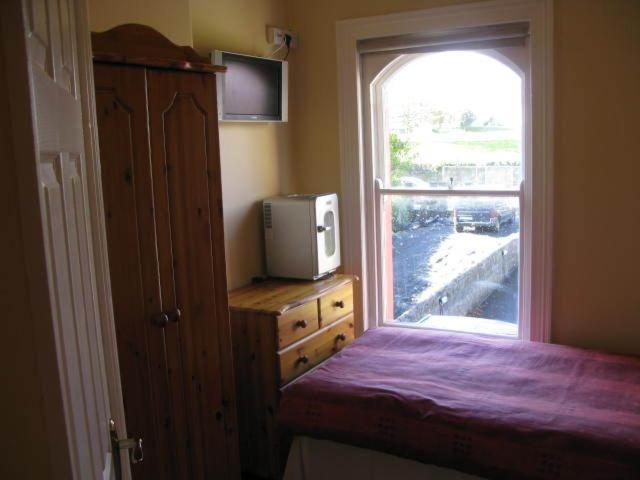 1 dormitorio con ventana y vestidor con TV en Dun Aoibhinn Guest Accommodation en Galway