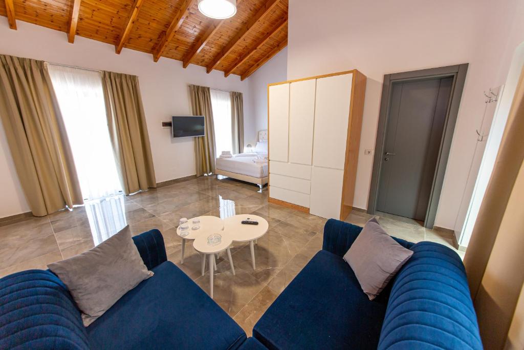 a living room with a blue couch and a table at Santa Oliva Suites in Ksamil