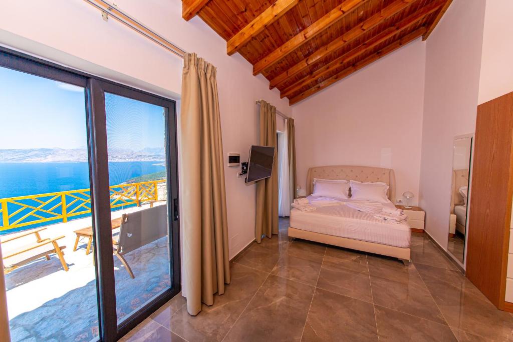 a bedroom with a bed and a view of the ocean at Santa Oliva Suites in Ksamil